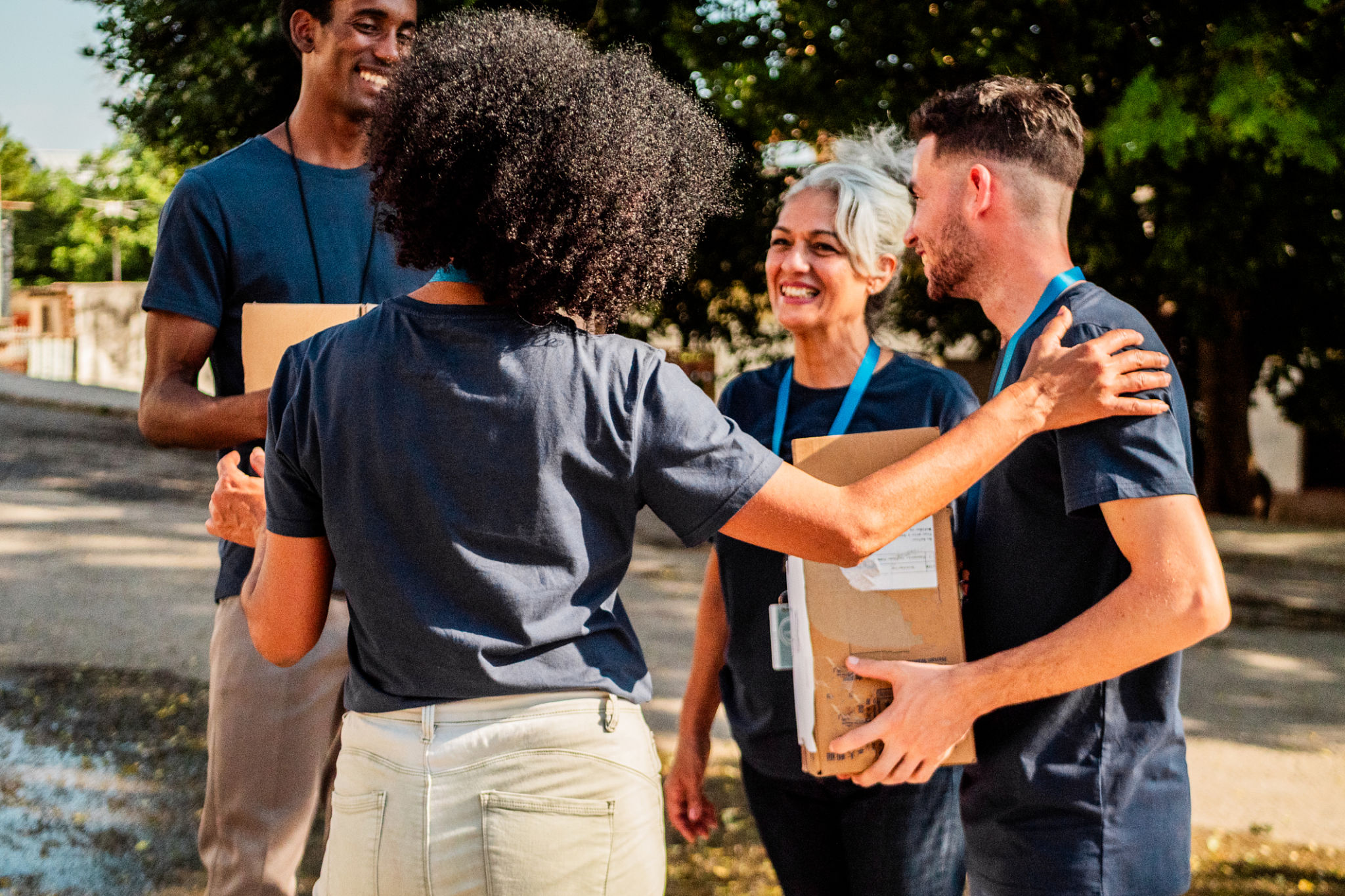 Volunteers holding donation boxes outdoors at a community event